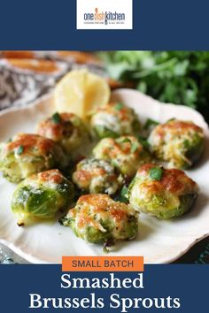 small batch brussel sprouts on a white plate with lemon wedges