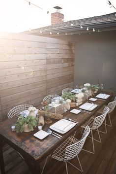 the table is set with plates and place settings on it, along with other items