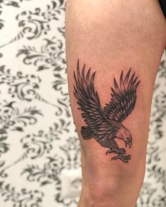 a black and white eagle tattoo on the leg