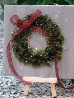 a christmas wreath is displayed on a easel