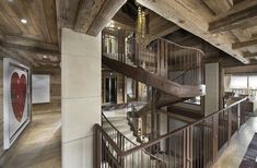 a spiral staircase in the middle of a room with wood paneling and walls on both sides