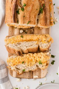 sliced bread with cheese and herbs on a cutting board