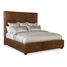 a bed with brown leather headboard and pillows on top of it, in front of a white background