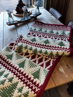 a crocheted blanket sitting on top of a wooden table