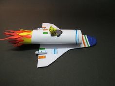 a paper model of a rocket ship with flames coming out of it