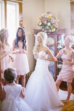 bridesmaids in pink dresses are dancing together