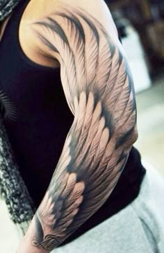 a man's arm with an angel wing tattoo on it