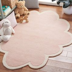 a teddy bear sitting on top of a pink rug