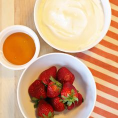 some strawberries and yogurt in bowls on a table