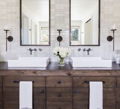 a bathroom with two sinks and mirrors on the wall