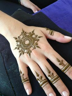 a woman's hand with henna tattoos on it