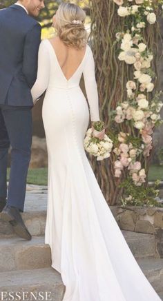 the bride and groom are walking down the steps in their wedding gowns with long sleeves