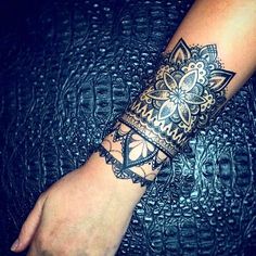 a woman's arm with a tattoo on it and an intricate design in the middle