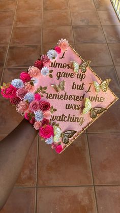 a pink graduation cap decorated with flowers on the side of a tile floor that says, i miss you but remembers who watching