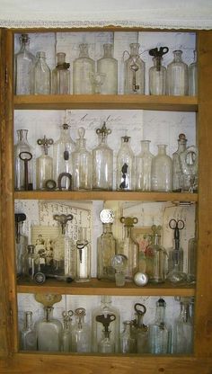 an old wooden shelf filled with lots of glass bottles