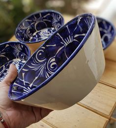 two blue and white bowls sitting on top of a wooden table next to each other