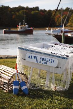 there are many boats in the water and one has a sign on it that says maine squeezeeze