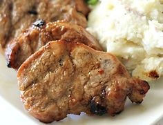 some meat and mashed potatoes on a white plate