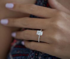 a woman's hand with a diamond ring on it