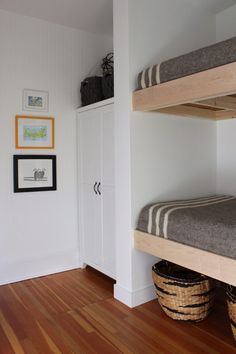 two bunk beds sitting next to each other on top of a hard wood floor in a room