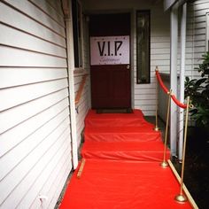 red carpeted steps leading up to the front door of a house with a sign on it