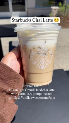 someone holding up a cup of coffee with the words starbucks's chai latte on it