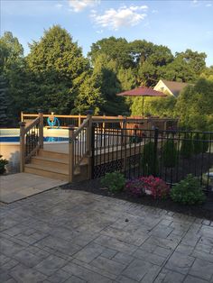 an outdoor swimming pool with steps leading up to it and flowers in the foreground