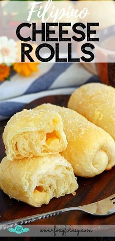 two pieces of cheese rolls on a plate with a fork next to it and flowers in the background