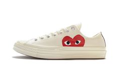 The Comme des Garçons PLAY x Converse Chuck 70 Ox “White” is the low-top edition of the popular collaborative sneaker by CDG and Converse in white.  The stylish and playful design features a “Milk” white canvas upper with CDG PLAY’s heart face logo peeking above the midsole in bright red.  The midsole matches the cream hue of the upper while silver lace eyelets and a black canvas stripe down the heel complete the design. Comme Des Garcons Sneakers, Converse Cdg, Comme Des Garcons Play Converse, Cdg Converse, Converse Chuck Taylor Low, Play Converse, White Chuck Taylors, Baskets Converse, Half Heart