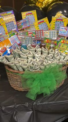 a basket filled with money sitting on top of a table next to balloons and streamers