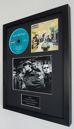 a black frame with two pictures and a cd on it