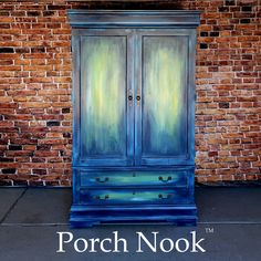 an old blue armoire painted with acrylic paint on brick wall in front of the porch nook logo