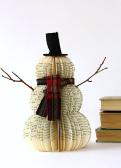 a snowman made out of books with a top hat and scarf on it's head