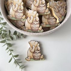 there is a bowl full of cookies with bears on them next to some green leaves