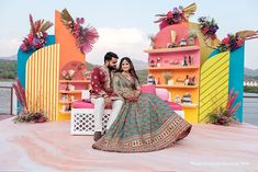 a man and woman sitting on top of a colorful stage