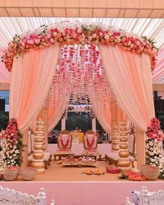 a decorated stage with flowers and chairs