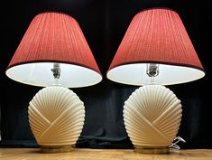 two lamps sitting next to each other on a wooden floor