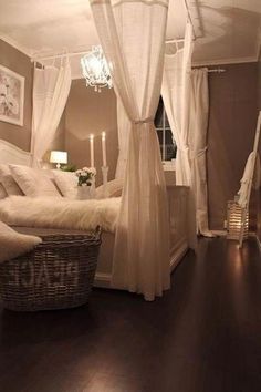 a white canopy bed sitting in a bedroom next to a window