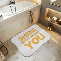 a bathroom rug that says shine just being you on the floor next to a bathtub