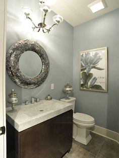 a bathroom with a toilet, sink and mirror in it's centerpieces