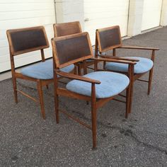 three wooden chairs sitting next to each other on the ground in front of a building