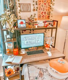 a desk with a computer on top of it next to a potted plant and other items