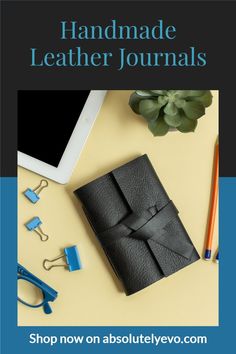 the handmade leather journal is on display next to an ipad, pencils and other items