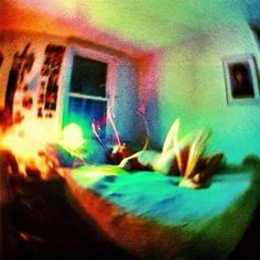 a blurry image of a bed in a room with a window and pictures on the wall