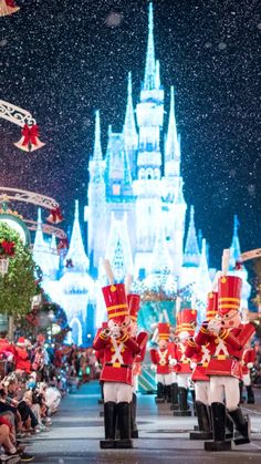 the nutcrackers are marching in front of the castle at christmas time with people watching