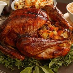 a roasted turkey on a platter with other dishes