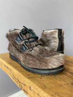 "Vintage fur boots with shearling interiors and fur exteriors. Black leather details and rubber bottom soles. The fur is a brown and white mixture.  Condition: very good, in insole is a bit yellowed, there is a bit of the heel rubbed as in the heel picture. Laces are missing a few end seals. Otherwise these are in excellent vintage condition. No issues with the fur. Labels/tags: Capitol, made in canada, size 5 Measurements: i can just squeeze my size 6 foot into these barely. Recommended for a 5 or 5.5 -inner length 9\"  *To ensure a great fit, we recommend comparing the measurements above to a similar garment you own and love to wear, as sizing varies across the decades.  *If ordering more than one item, I will adjust shipping costs and refund the difference as shipping has been added int Boots Fur, Reindeer Sweater, Vintage Fur, Fur Boots, Boots Fall, Cream Dress, Vintage Wool, Boot Shoes Women, New Vintage