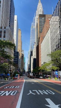 an empty city street with tall buildings in the background