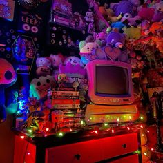 an old tv sitting on top of a dresser covered in stuffed animals and other toys