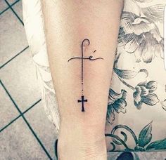 a woman's foot with a cross tattoo on it